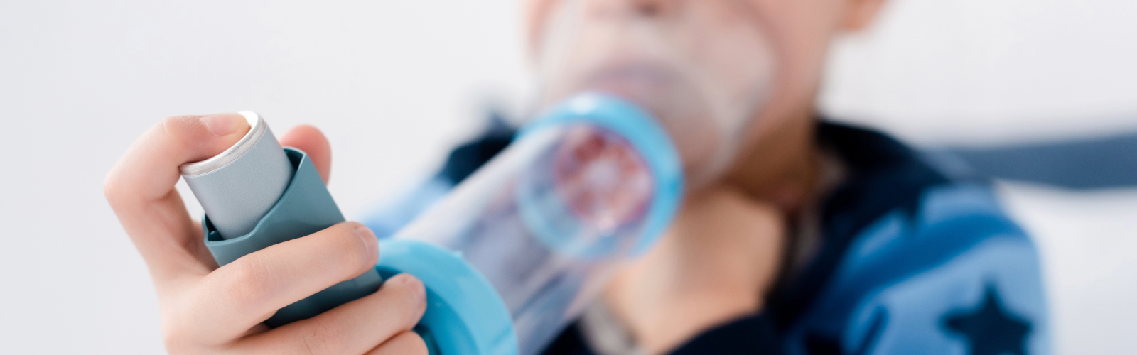 Child using asthma spacer