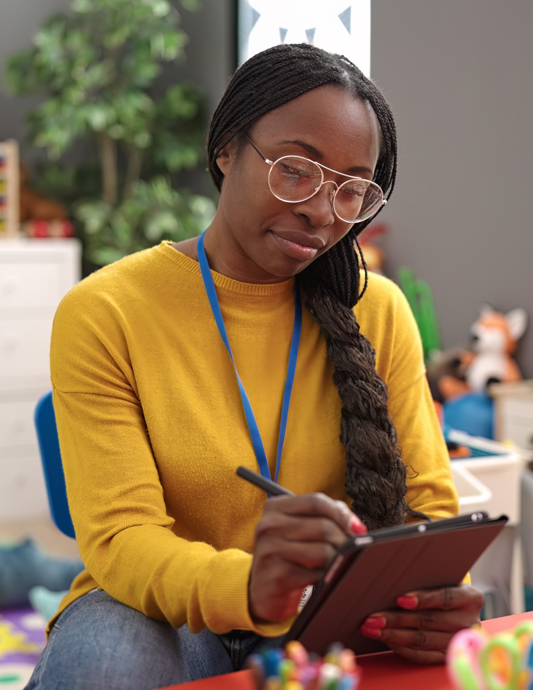 Early childhood educator in a classroom with a checklist